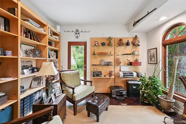 a bedroom with a bed and dresser with potted plants