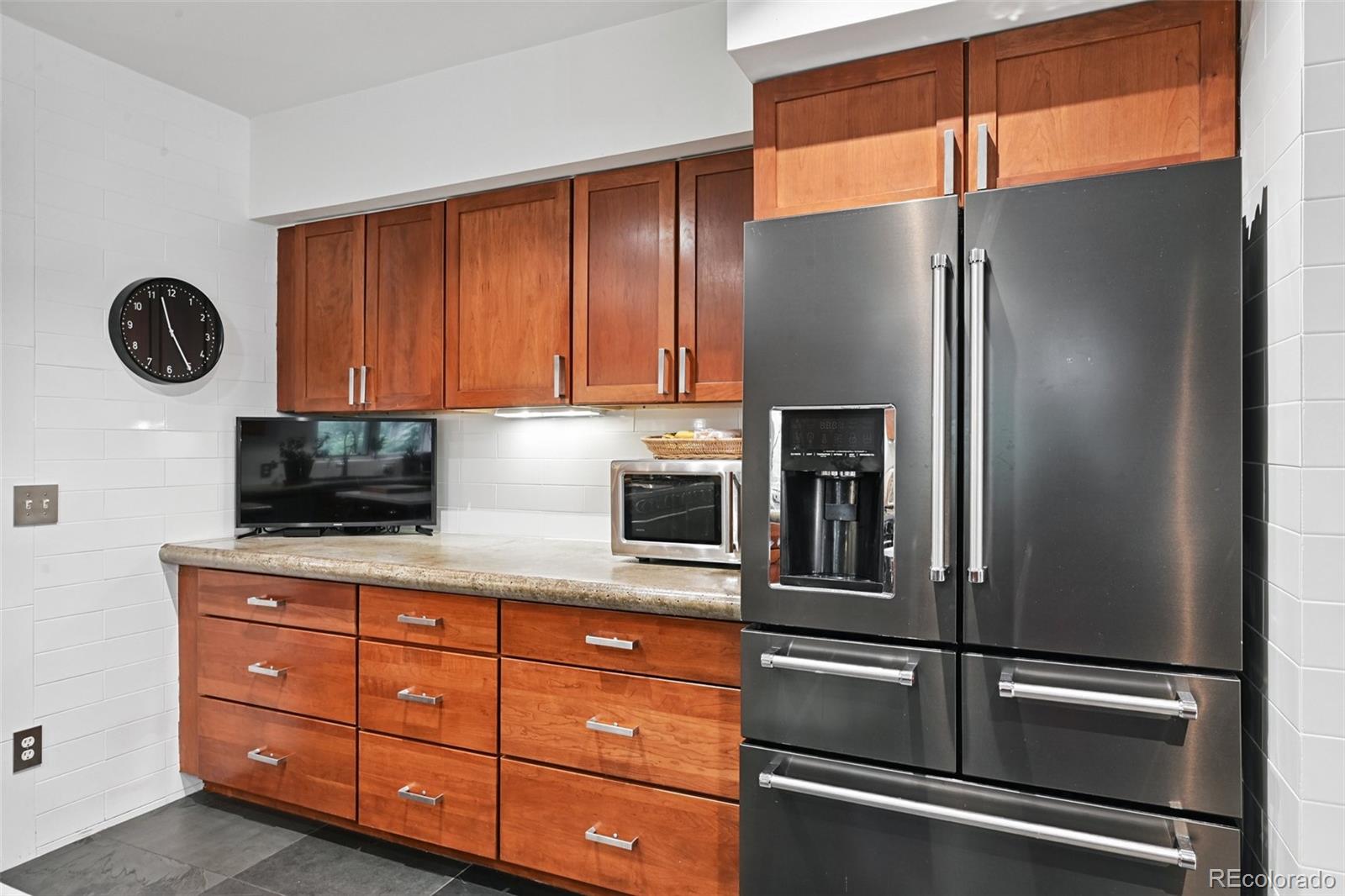 3391 Oak Street Wheat Ridge, CO 80033 - Photo 17 of 50 a kitchen with granite countertop stainless steel appliances and wooden cabinets