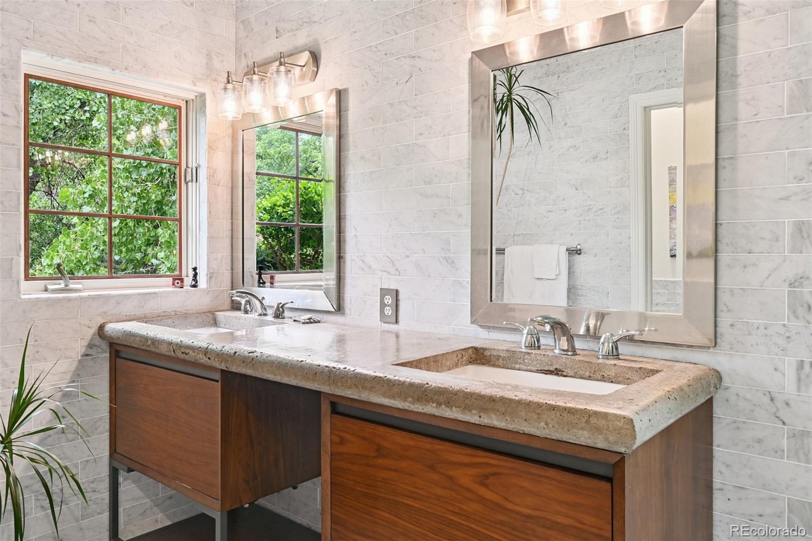 3391 Oak Street Wheat Ridge, CO 80033 - Photo 21 of 50 a bathroom with a granite countertop sink a mirror and a window