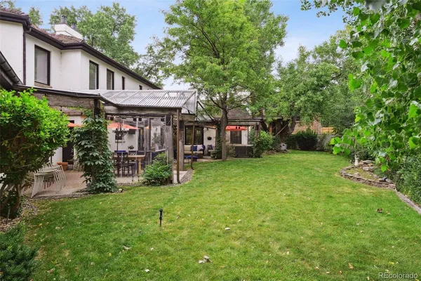 an aerial view of residential houses with outdoor space and trees