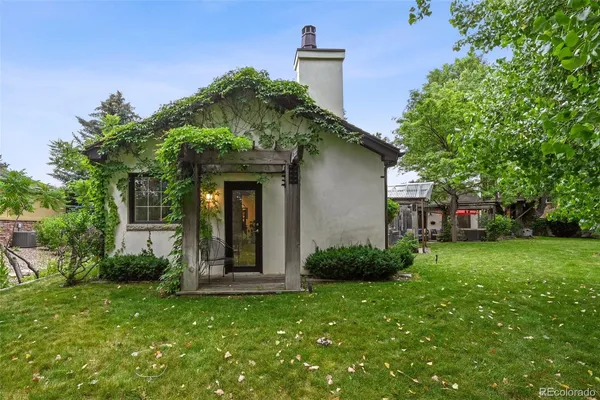 a view of a house with a yard and large trees
