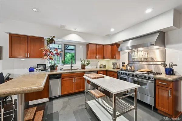 a kitchen with stainless steel appliances kitchen island granite countertop a sink and cabinets