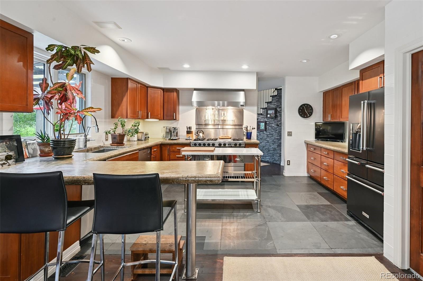 3391 Oak Street Wheat Ridge, CO 80033 - Photo 6 of 50 a kitchen with stainless steel appliances kitchen island granite countertop a sink and cabinets