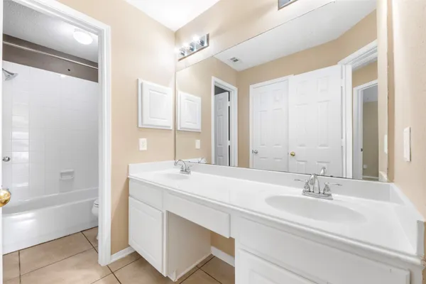 a bathroom with a sink double vanity granite tub shower and a mirror