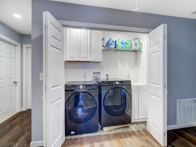 a utility room with wooden floor washer and dryer