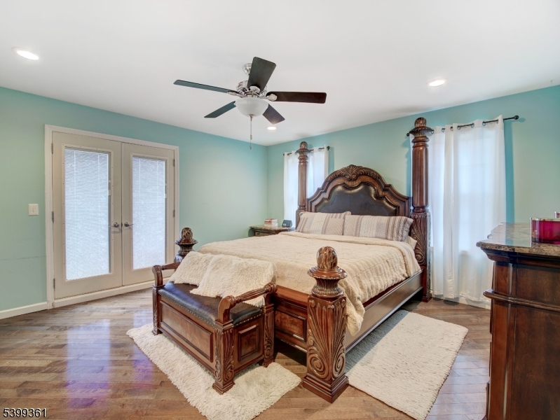 2 Papakating Road Hopatcong, NJ 07843 - Photo 14 of 28 a spacious bedroom with a bed and a chandelier