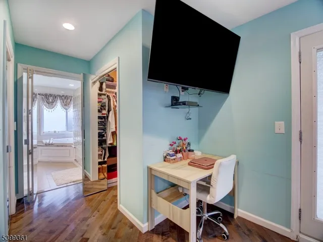 a view of a livingroom with furniture a flat screen tv and wooden floor
