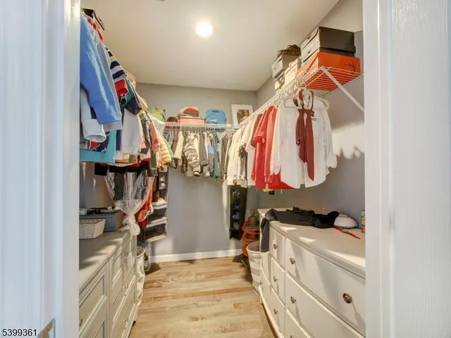 a view of walk in closet with clothes and shoes