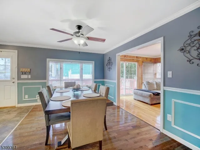 a dining room with furniture a chandelier and wooden floor