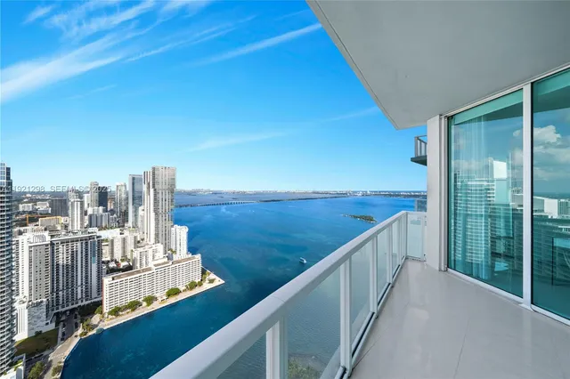 a dining room with stainless steel appliances furniture a rug and a kitchen view