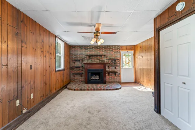 a view of an empty room with a fireplace and a window
