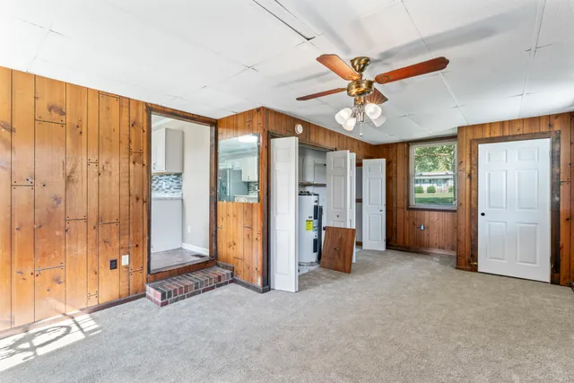 an empty room with fan and windows