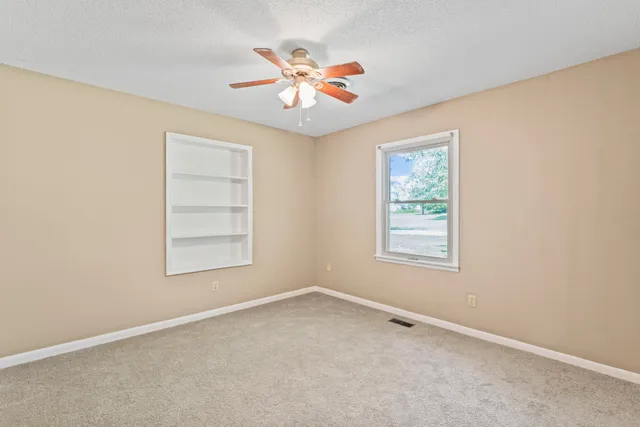 an empty room with window and closet