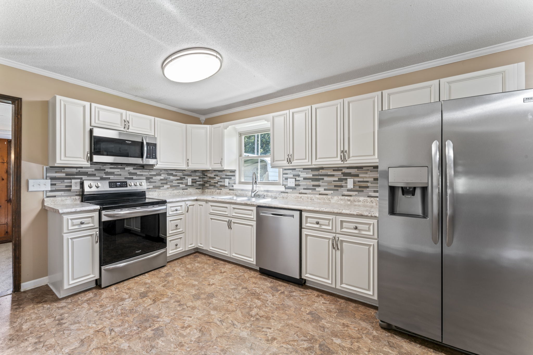 499 Ridgewood Drive Manchester, TN 37355 - Photo 9 of 37 a kitchen with white cabinets stainless steel appliances and a window