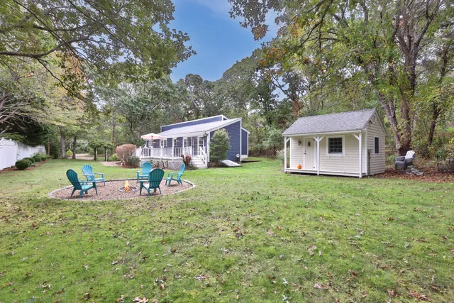 a view of a house with backyard and sitting area