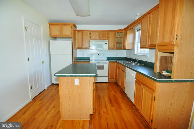 a kitchen with stainless steel appliances granite countertop a sink a stove cabinets and wooden floor