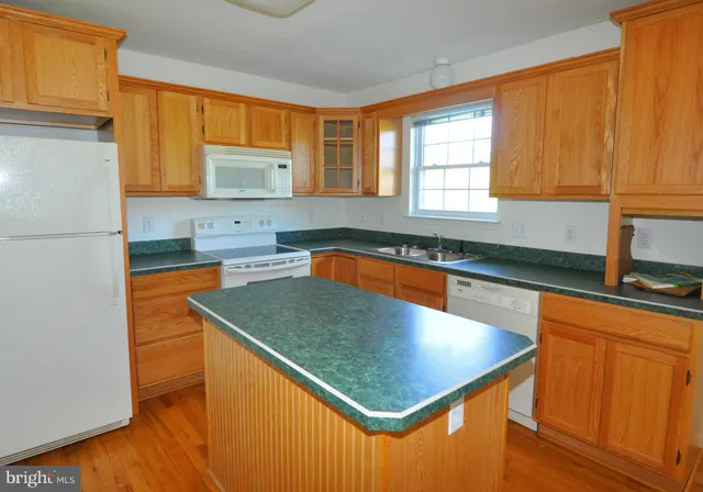 a kitchen with stainless steel appliances granite countertop a sink a refrigerator and a stove