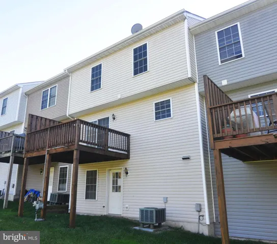 a view of a house with wooden deck and a yard