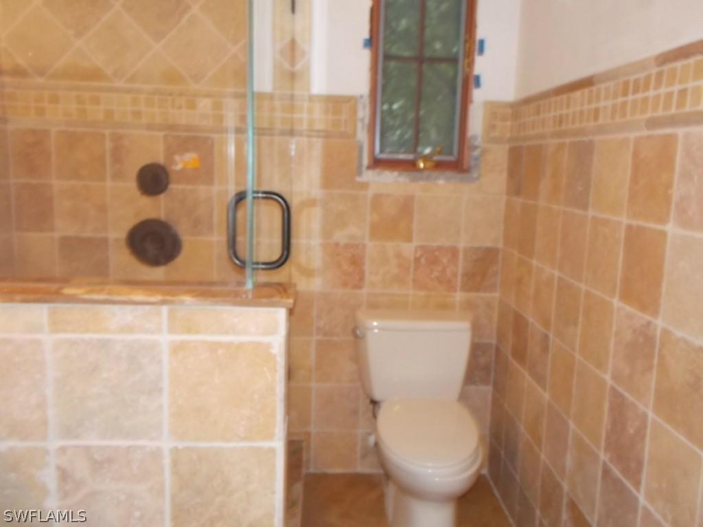1657 Ardmore Road Fort Myers, FL 33901 - Photo 7 of 14 a white toilet sitting next to a shower