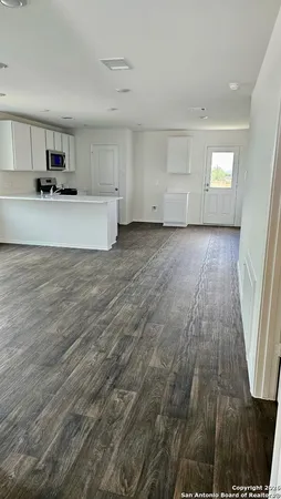a view of a kitchen with wooden floor and electronic appliances
