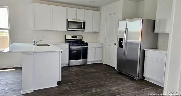 a kitchen with stainless steel appliances a refrigerator stove and microwave