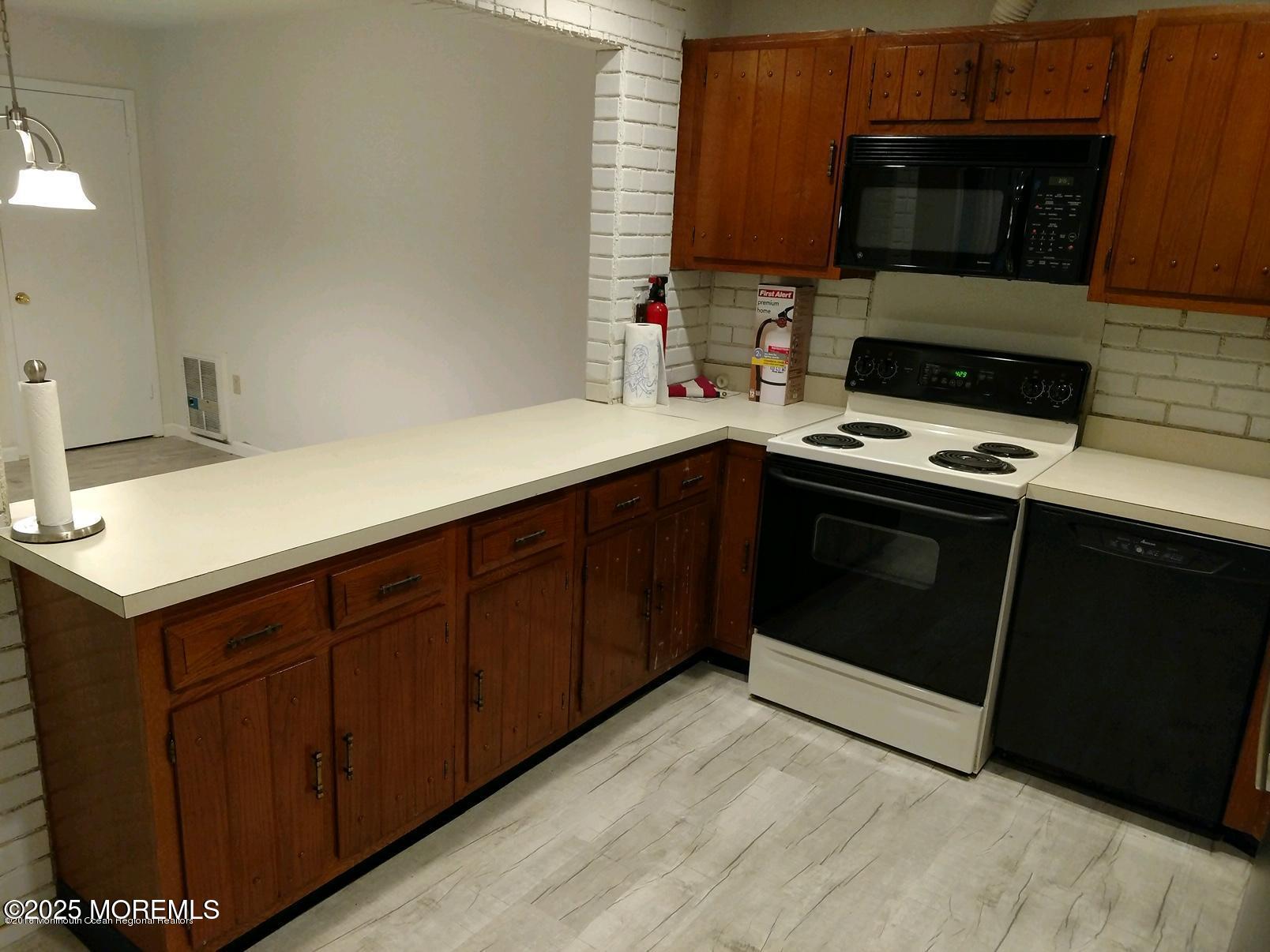 137 Amberly Drive, Unit E Manalapan, NJ 07726 - Photo 11 of 24 a kitchen with a stove and a microwave