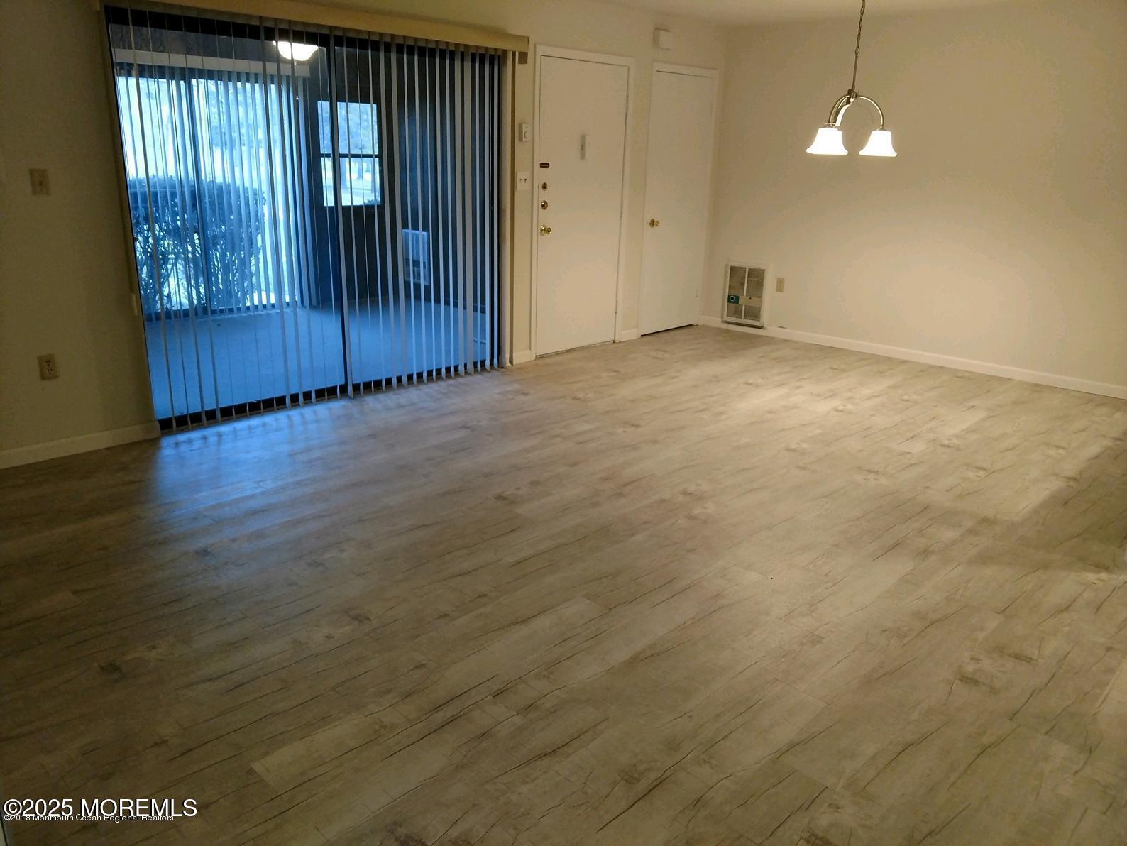 137 Amberly Drive, Unit E Manalapan, NJ 07726 - Photo 16 of 24 an empty room with wooden floor windows and entryway