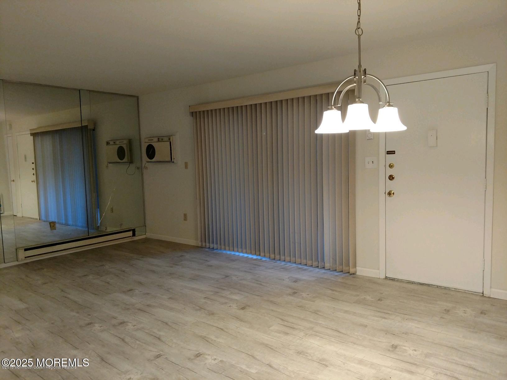 137 Amberly Drive, Unit E Manalapan, NJ 07726 - Photo 18 of 24 a view of an empty room with a chandelier