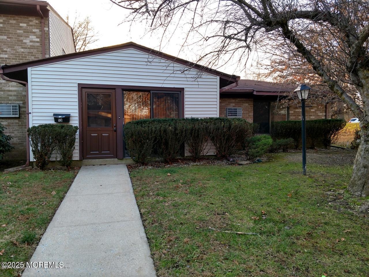 137 Amberly Drive, Unit E Manalapan, NJ 07726 - Photo 2 of 24 a front view of a house with garden