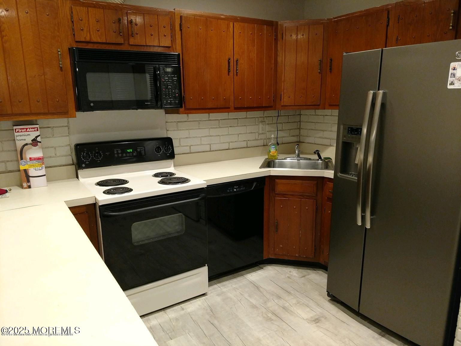 137 Amberly Drive, Unit E Manalapan, NJ 07726 - Photo 7 of 24 a kitchen with a sink stove and refrigerator