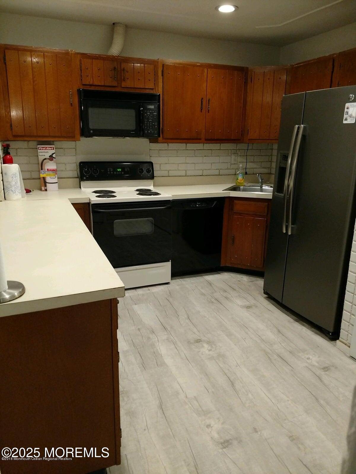 137 Amberly Drive, Unit E Manalapan, NJ 07726 - Photo 9 of 24 a kitchen with stainless steel appliances a refrigerator a stove a microwave a sink and cabinets