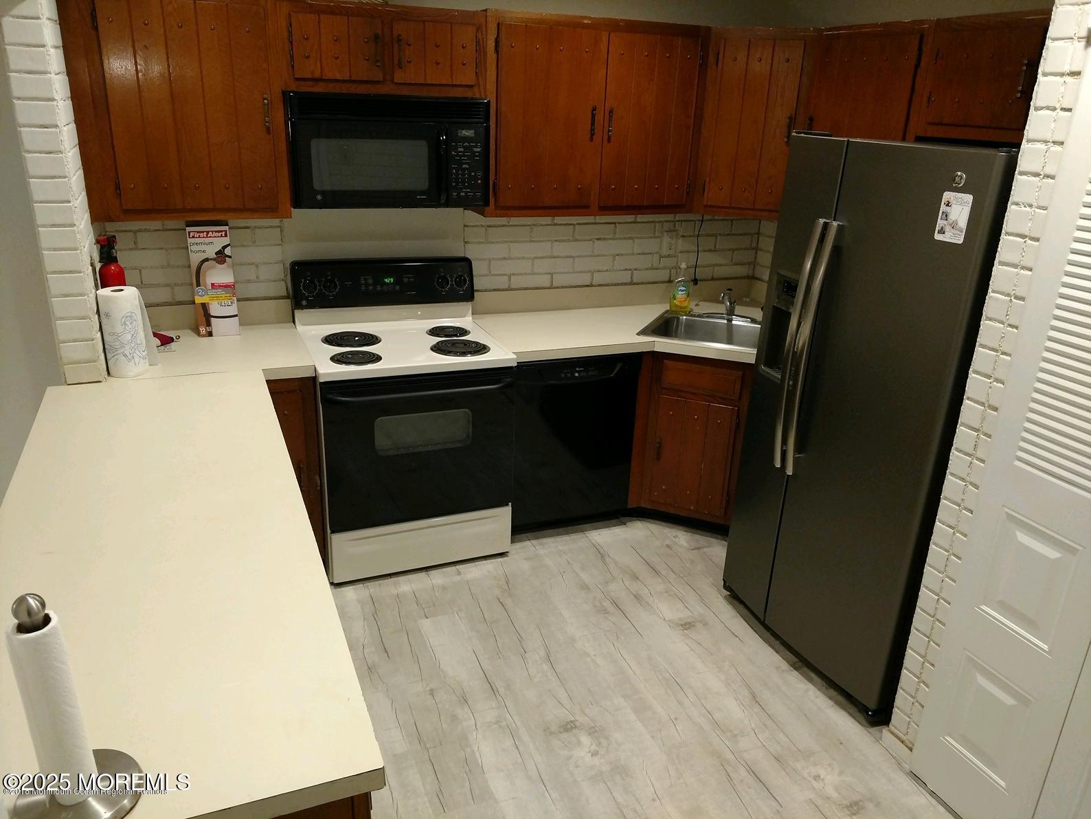 137 Amberly Drive, Unit E Manalapan, NJ 07726 - Photo 10 of 24 a kitchen with a refrigerator stove and microwave