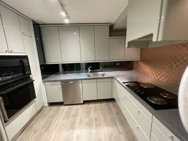 a kitchen with a sink a stove and cabinets