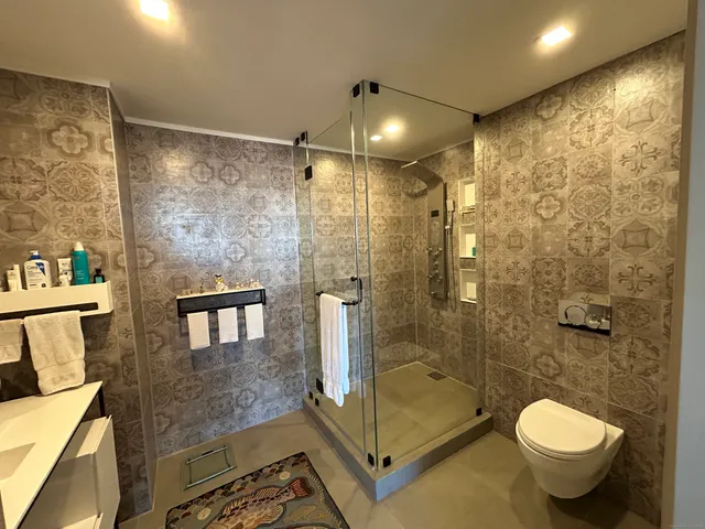 a bathroom with a granite countertop sink toilet and shower