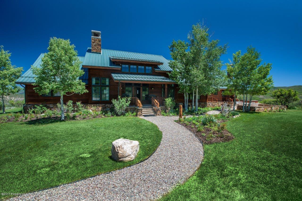 a view of a house with a yard potted plants and a bench