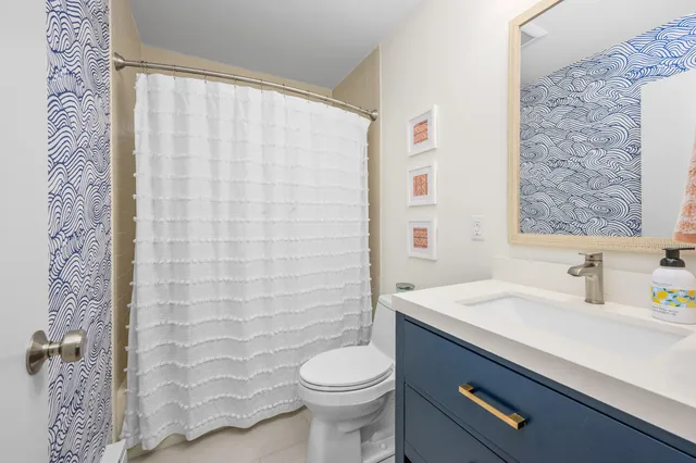 a bathroom with a sink a toilet and shower curtain