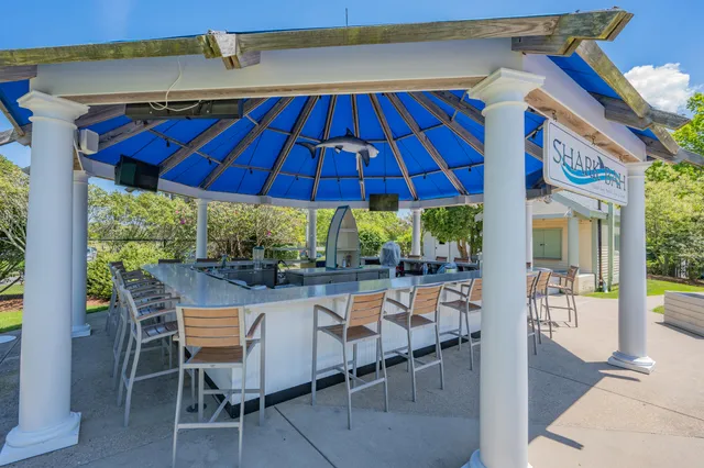 a view of patio with chairs and table under an umbrella