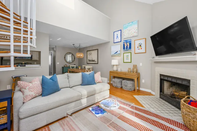 a living room with furniture a flat screen tv and a fireplace