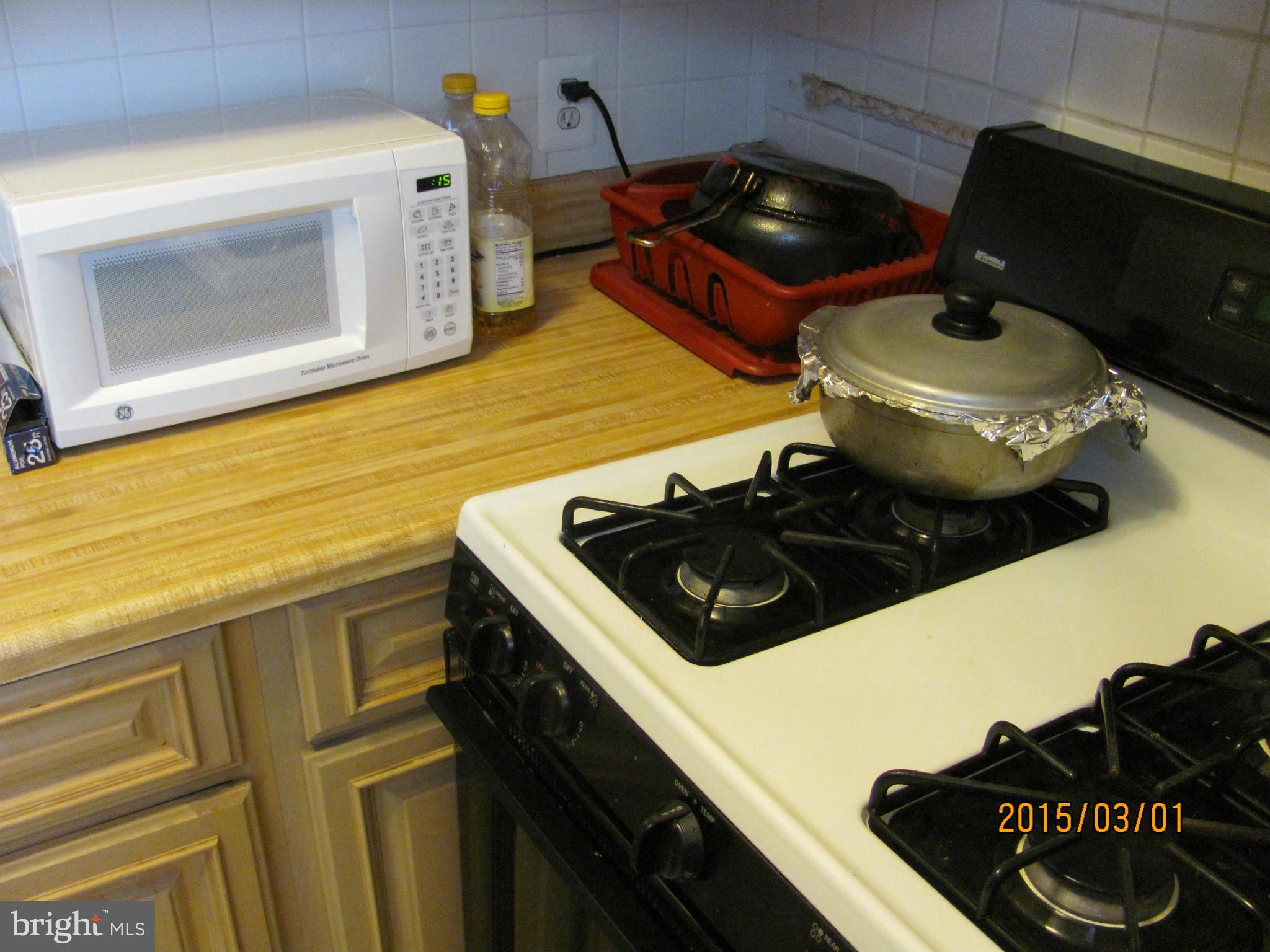 704 Quincy Street Northwest, Unit 202 Washington, DC 20011 - Photo 21 of 24 a kitchen with a stove and a microwave