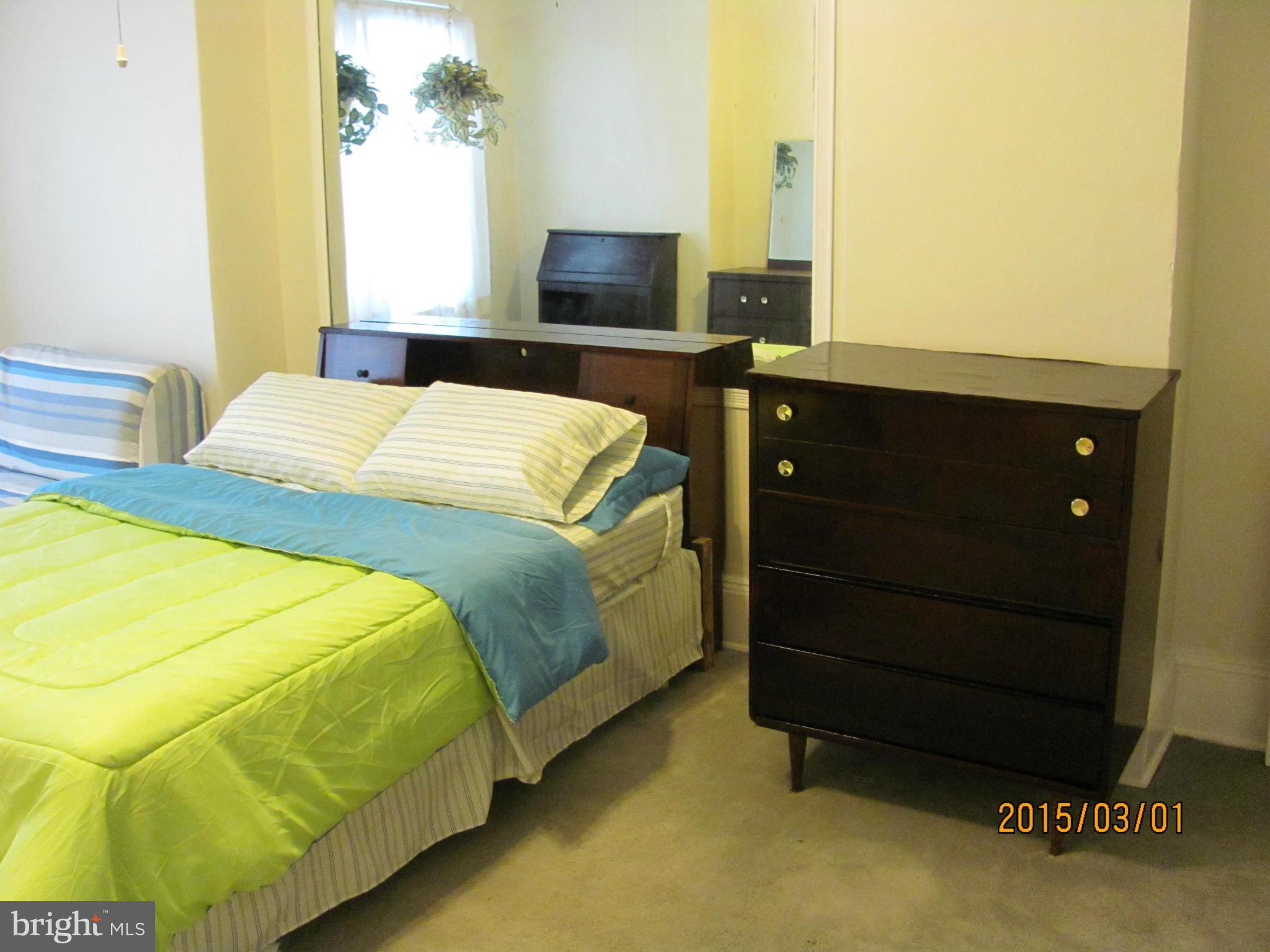 704 Quincy Street Northwest, Unit 202 Washington, DC 20011 - Photo 4 of 24 a bedroom with a bed and a flat tv screen on dresser