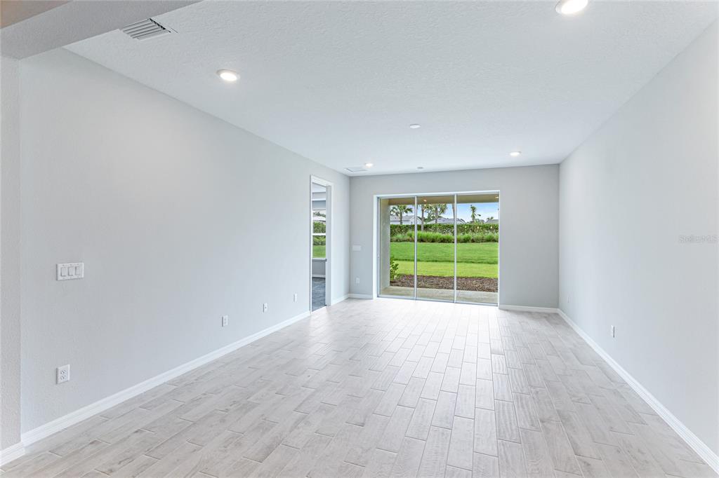 8440 Skye Rnch Boulevard Sarasota, FL 34241 - Photo 15 of 86 a view of an empty room with wooden floor and a window