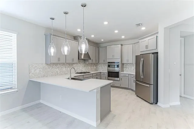 a kitchen with stainless steel appliances a refrigerator sink and cabinets