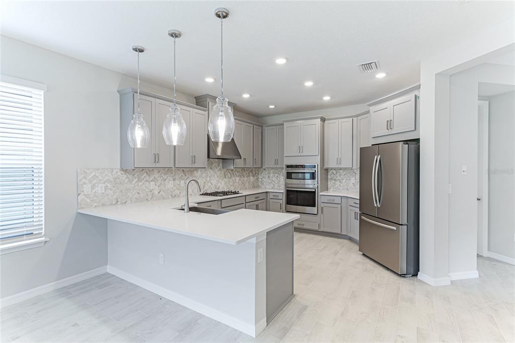8440 Skye Rnch Boulevard Sarasota, FL 34241 - Photo 9 of 86 a kitchen with a refrigerator a sink and a oven