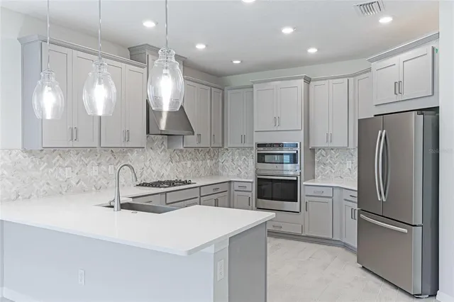 a kitchen with kitchen island a sink appliances and a window