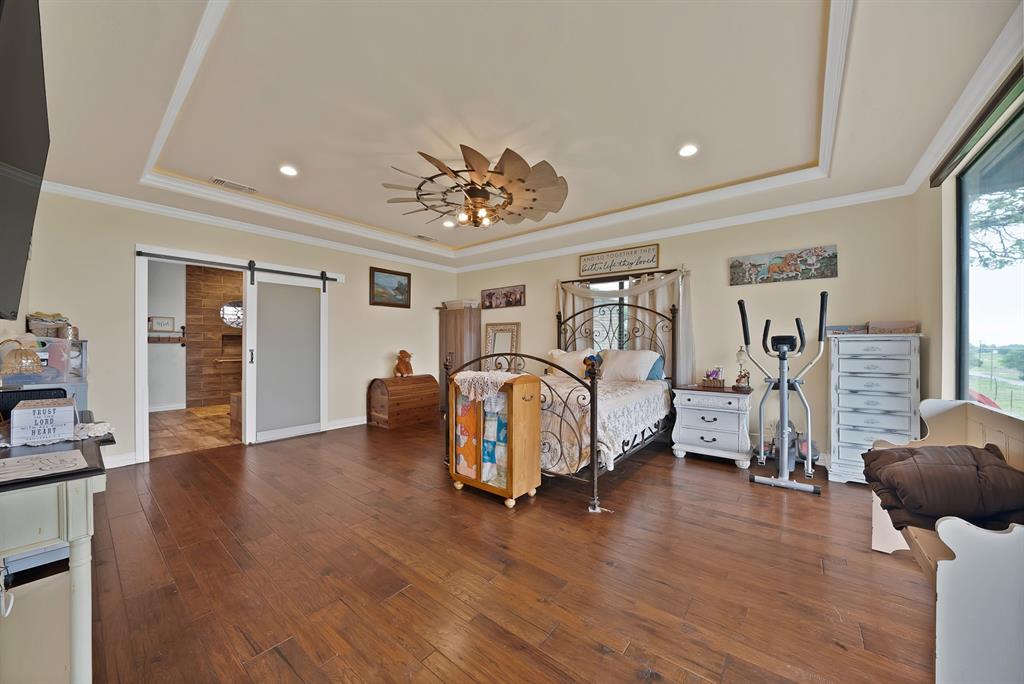 100 Shadle Ridge Court Poolville, TX 76487 - Photo 16 of 40 Spacious room featuring wood-finish flooring, a tray ceiling with recessed lighting, and a decorative ceiling fan