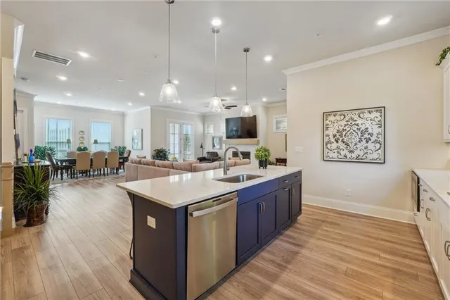 a kitchen with stainless steel appliances granite countertop a dining table chairs refrigerator and sink