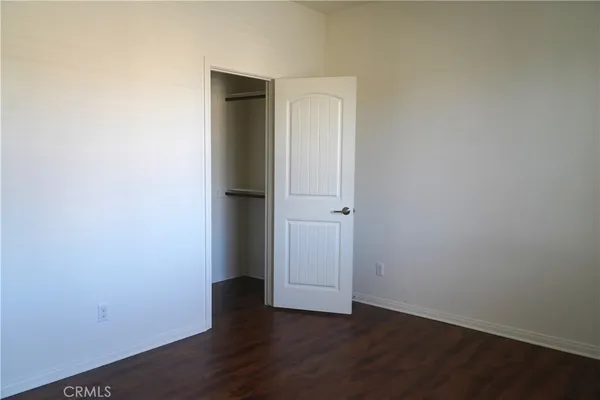 an empty room with wooden floor and closet