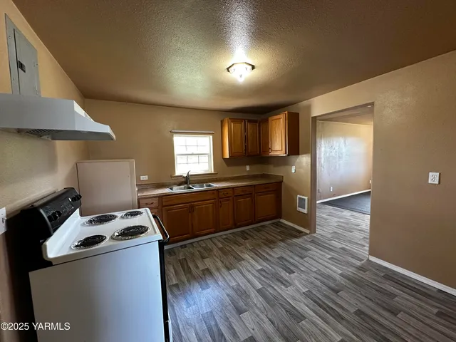 a kitchen with kitchen island a counter space a sink and a stove