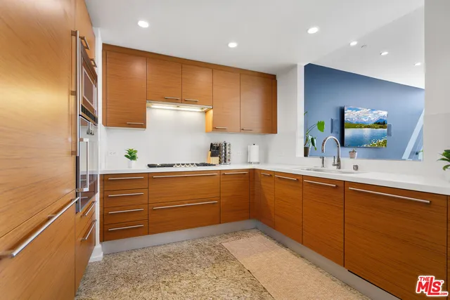 a kitchen with stainless steel appliances granite countertop a sink a stove and a refrigerator