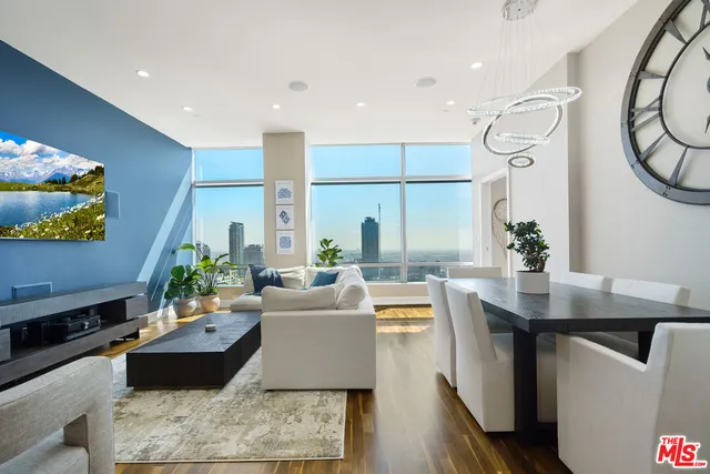 a living room with furniture wooden floor and a large window